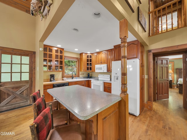 3541 Twin Pines Way, Sevierville, TN 37876 - kitchen with white appliances, a sink, glass insert cabinets, a center island, and a kitchen bar