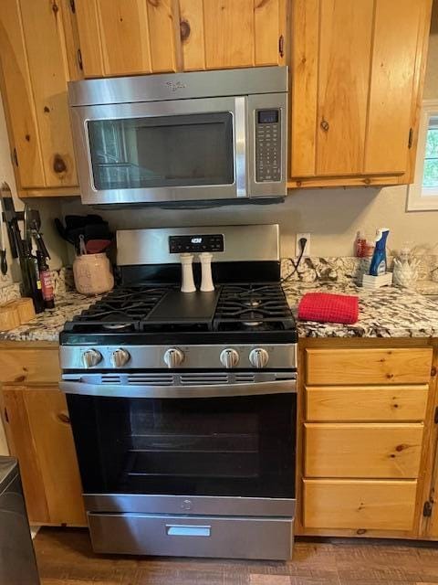 kitchen featuring stainless steel appliances and light stone counters