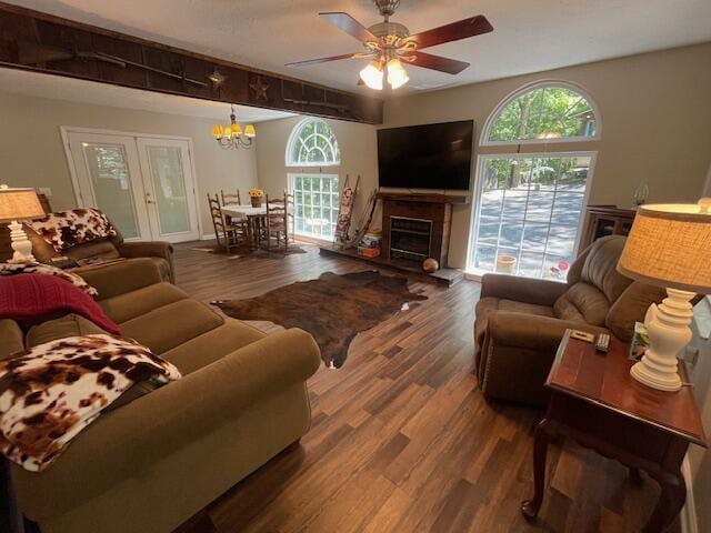 living room featuring ceiling fan with notable chandelier and dark hardwood / wood-style floors