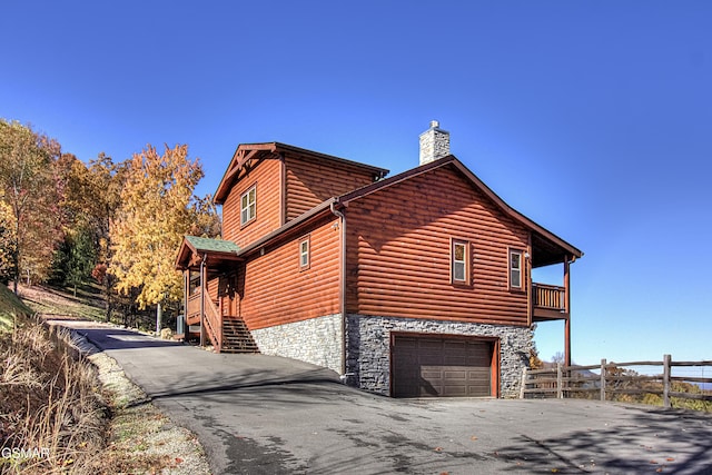 2422 Majestic View Way, Sevierville, TN 37862 - view of side of property featuring log veneer siding, stone siding, a garage, a chimney, and driveway