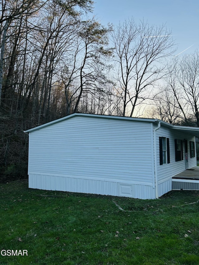 view of side of home with a lawn