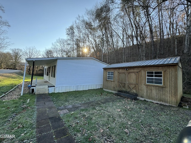 view of property exterior with an outbuilding, a storage unit, and a yard