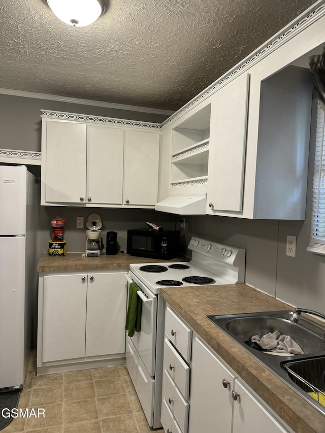 kitchen with black microwave, range hood, freestanding refrigerator, white electric stove, and a sink