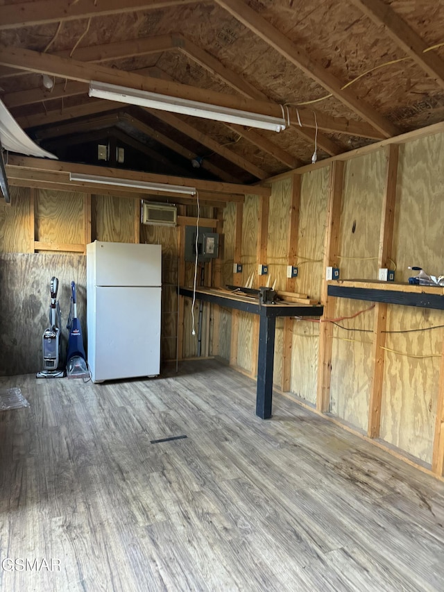 below grade area with wood finished floors and freestanding refrigerator
