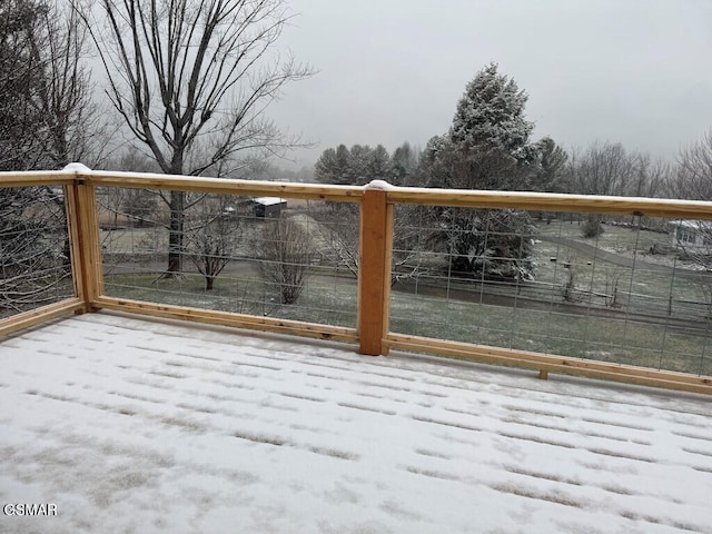 snow covered gate featuring a rural view