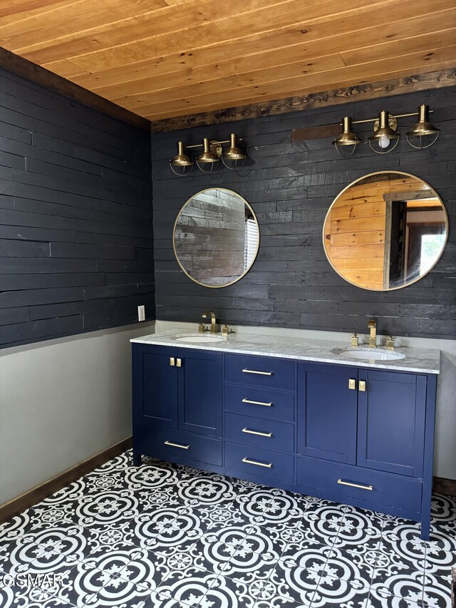 bathroom with tile patterned flooring, wood ceiling, a sink, and double vanity