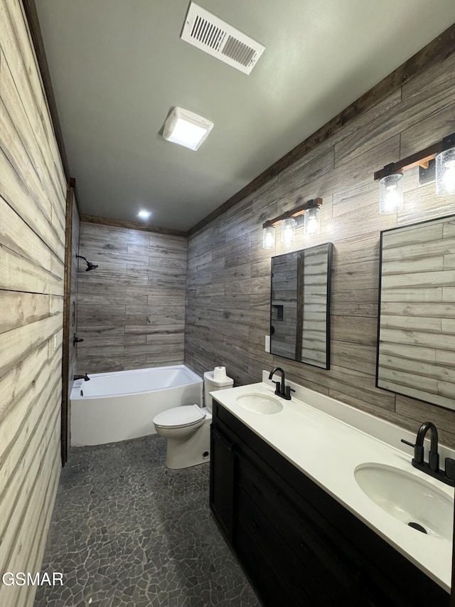 bathroom featuring toilet, tub / shower combination, a sink, and visible vents