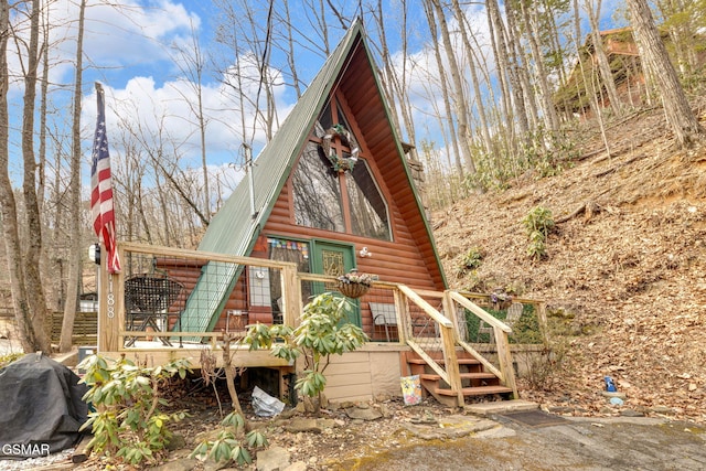 exterior space with metal roof and log veneer siding