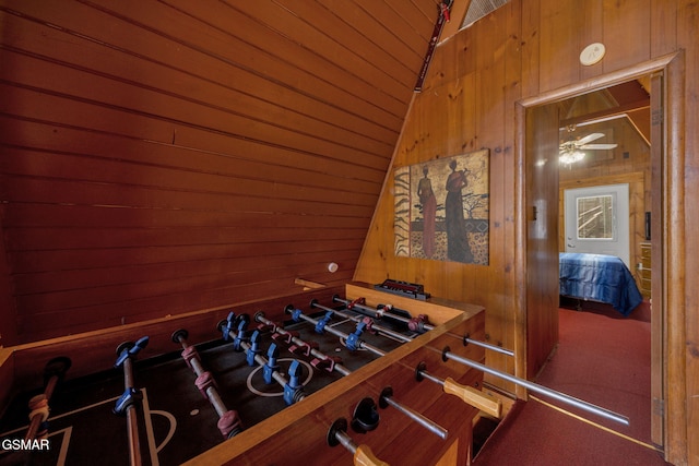 game room with wooden walls and vaulted ceiling