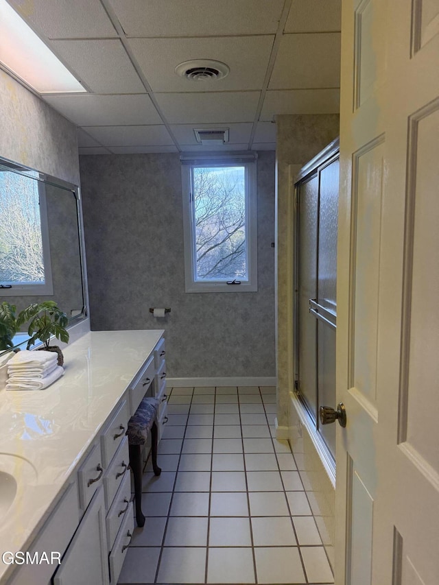 full bath with vanity, a shower with door, and visible vents