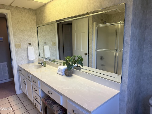 bathroom featuring visible vents, a shower with door, vanity, and tile patterned floors