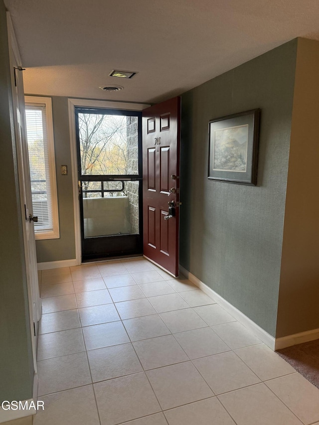 entryway featuring light tile patterned floors, visible vents, and baseboards