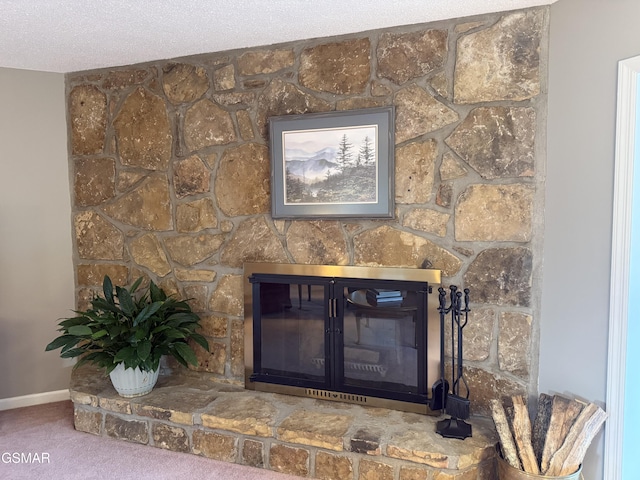 interior details with carpet floors, baseboards, a textured ceiling, and a glass covered fireplace