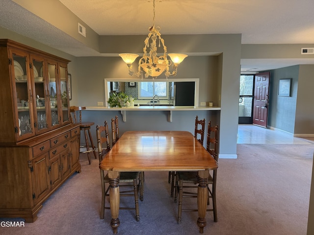 dining room featuring visible vents, a chandelier, a wealth of natural light, and light colored carpet