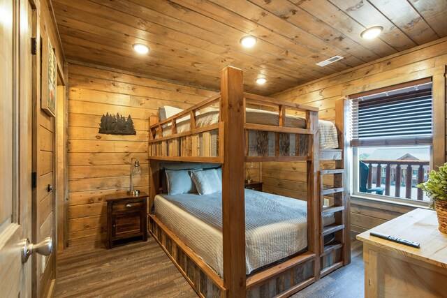 bedroom with dark hardwood / wood-style flooring, wood walls, and wood ceiling