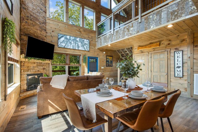 dining space with a fireplace, hardwood / wood-style floors, and a high ceiling