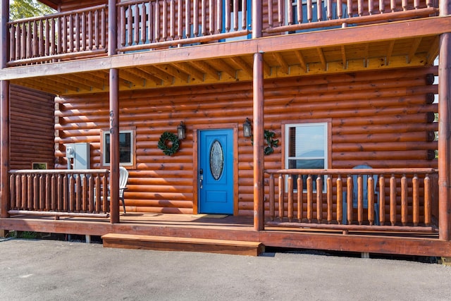 view of exterior entry with a balcony