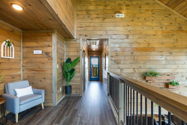 hall featuring wood walls, wood ceiling, and vaulted ceiling