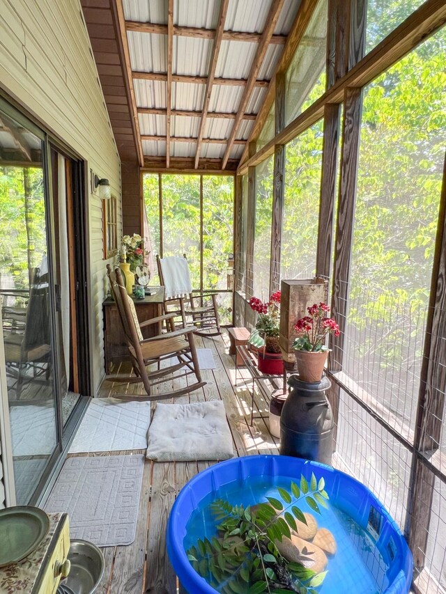 sunroom / solarium featuring vaulted ceiling