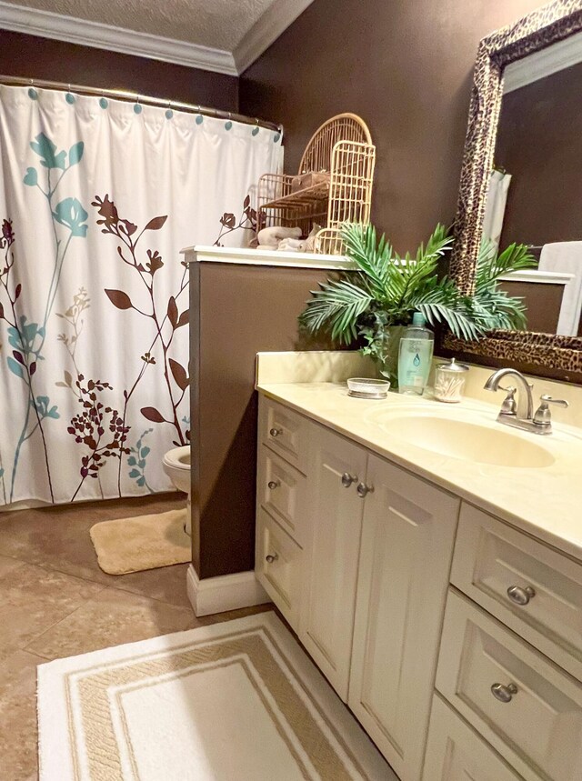 bathroom with toilet, vanity, and ornamental molding