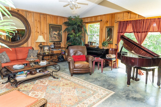 living room featuring concrete floors, wooden walls, ceiling fan, and lofted ceiling