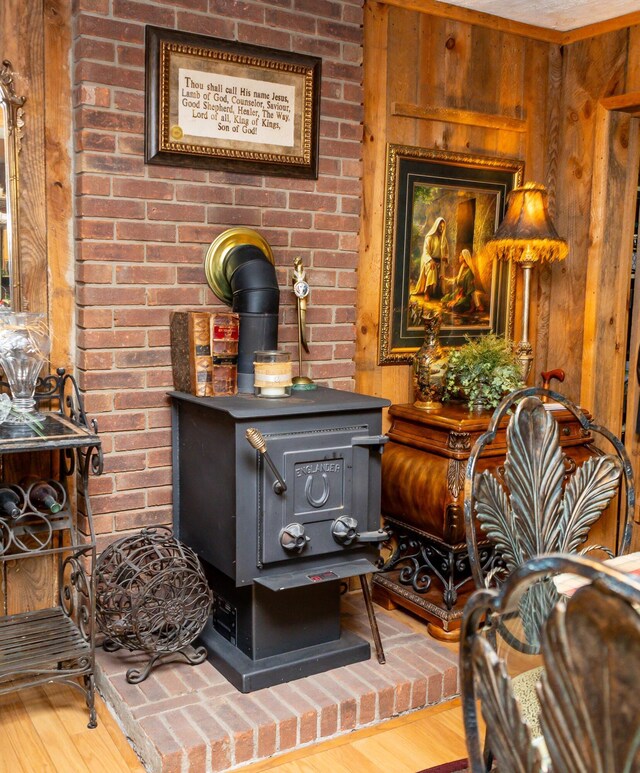 details featuring wood-type flooring, a wood stove, and wooden walls