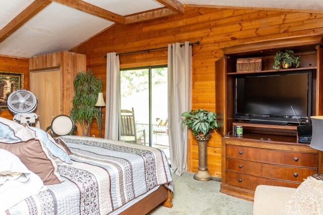 carpeted bedroom with access to outside, vaulted ceiling with beams, and wooden walls