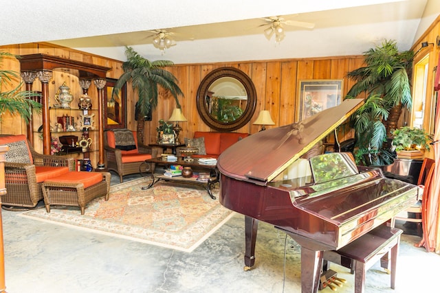 miscellaneous room featuring wood walls, ceiling fan, and concrete floors