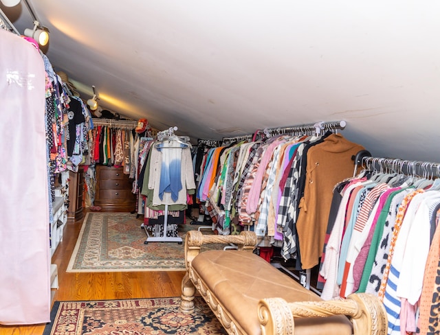 walk in closet featuring hardwood / wood-style floors and lofted ceiling