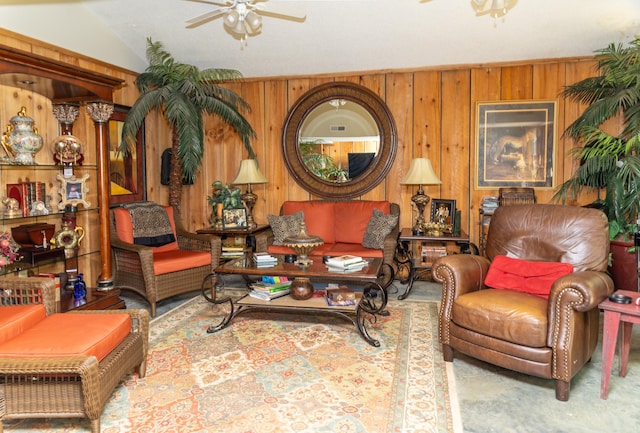 living room with ceiling fan, lofted ceiling, and wood walls