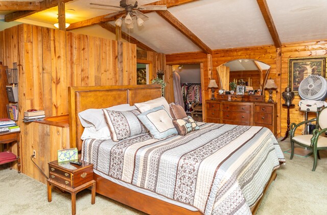 bedroom with ceiling fan, wood walls, carpet floors, and lofted ceiling with beams