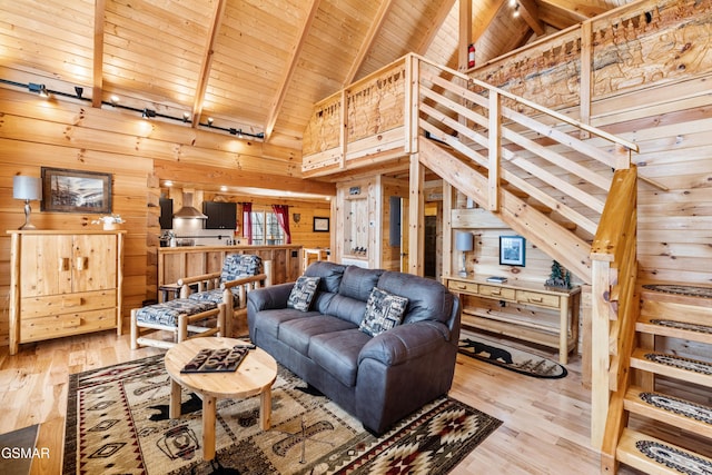 living room with beamed ceiling, wood finished floors, wood walls, and wood ceiling