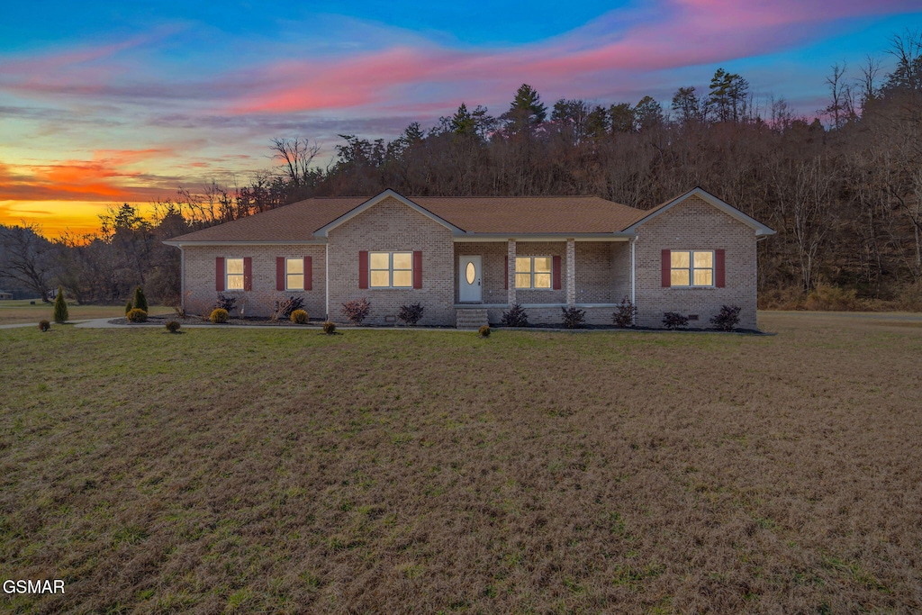 single story home with a yard and covered porch