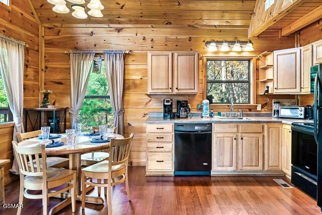 kitchen featuring black appliances, light brown cabinets, sink, and vaulted ceiling