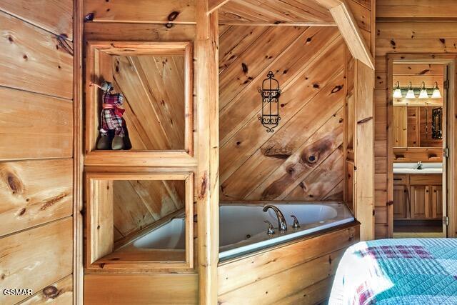 interior space featuring wood walls, a bathtub, and vanity