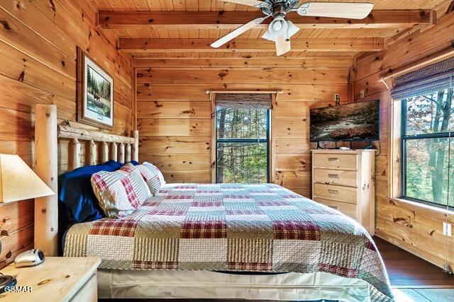 bedroom featuring beamed ceiling, wood walls, and wood ceiling