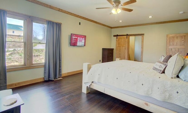 bedroom featuring ceiling fan, a barn door, ornamental molding, and dark wood-type flooring