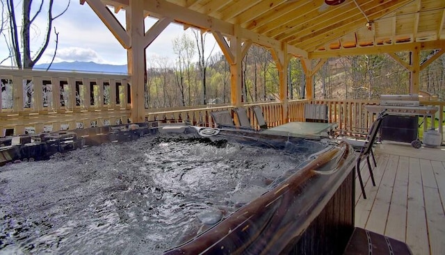 wooden deck with grilling area and a hot tub