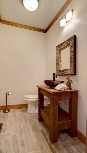 bathroom with vanity, toilet, and ornamental molding