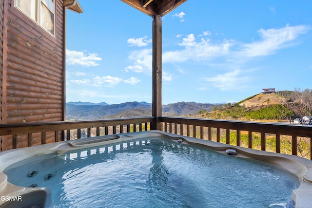 view of pool with a hot tub and a mountain view