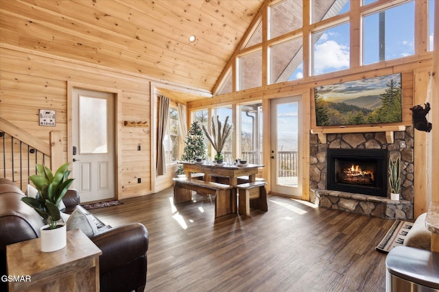 living room with dark hardwood / wood-style flooring, high vaulted ceiling, a stone fireplace, and wooden ceiling