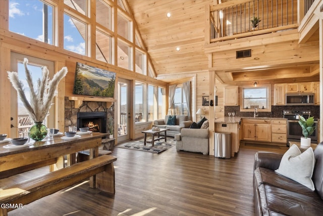 living room with dark wood-type flooring, a stone fireplace, sink, high vaulted ceiling, and wooden ceiling