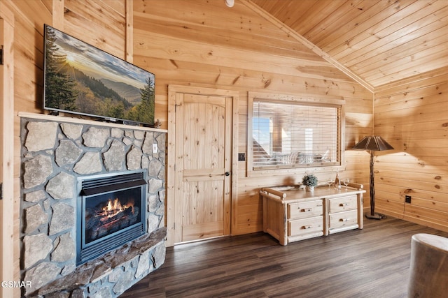 interior space featuring lofted ceiling, wood walls, wooden ceiling, dark hardwood / wood-style flooring, and a fireplace