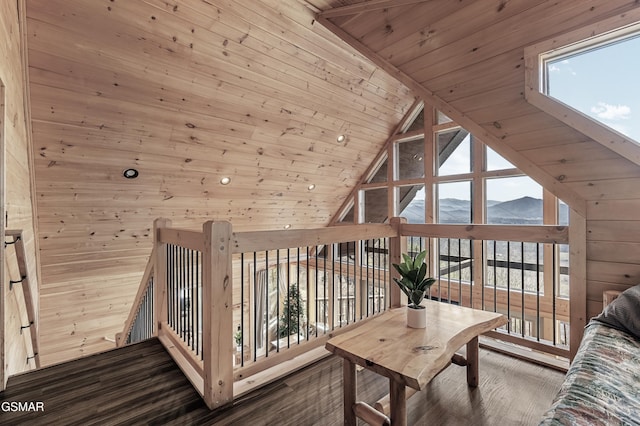 interior space with vaulted ceiling, wooden walls, dark hardwood / wood-style flooring, a mountain view, and wooden ceiling