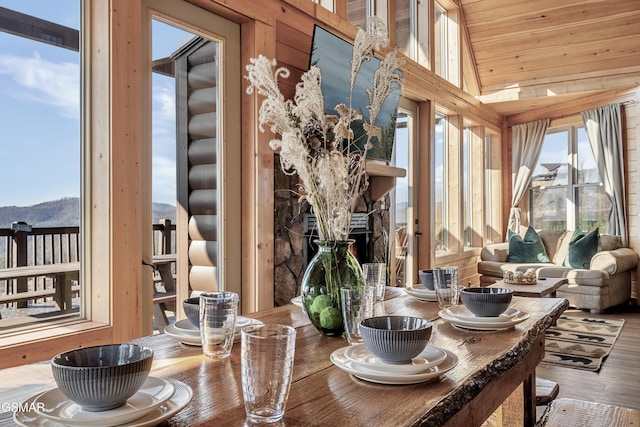 sunroom / solarium with vaulted ceiling, wood ceiling, and a fireplace