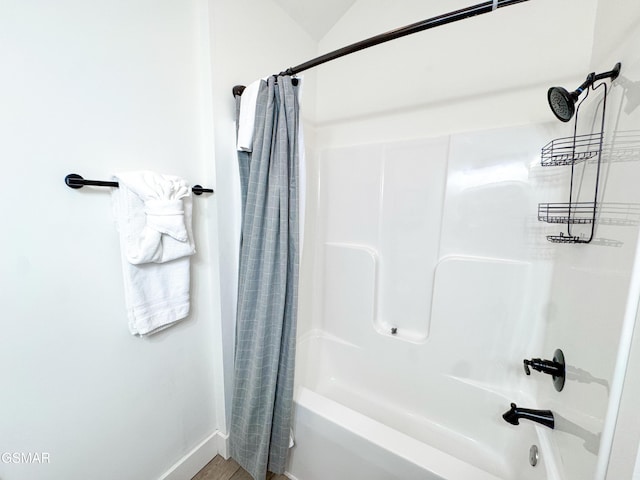 bathroom featuring shower / bathtub combination with curtain and baseboards