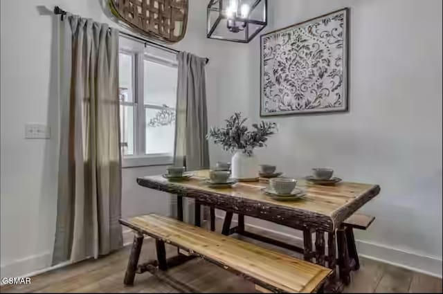 dining space featuring baseboards and wood finished floors