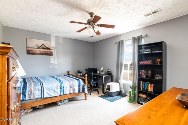 carpeted bedroom with visible vents, ceiling fan, and a textured ceiling