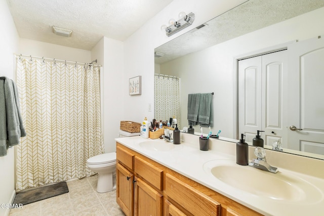 bathroom with double vanity, a textured ceiling, toilet, and a sink