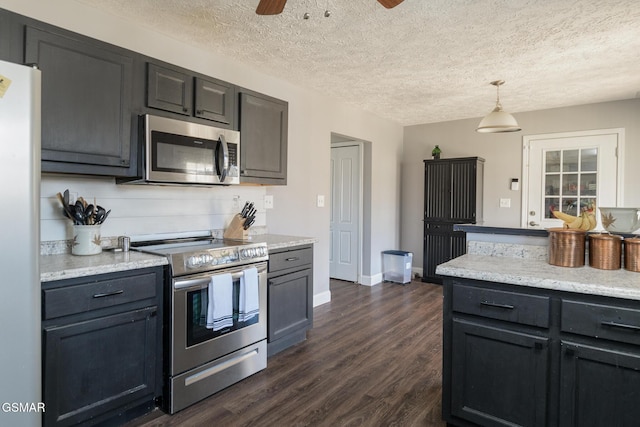 kitchen featuring a textured ceiling, stainless steel appliances, dark wood-type flooring, a ceiling fan, and decorative light fixtures